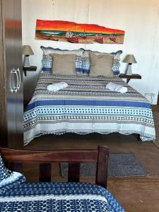 een slaapkamer met een groot bed met blauwe en witte lakens bij Frente playa in Punta Del Diablo