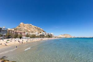 uma praia com um monte de pessoas e o oceano em Paloma-habitacion del piso em Alicante