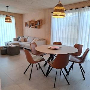 ein Wohnzimmer mit einem Tisch, Stühlen und einem Sofa in der Unterkunft Dunehuys in Koksijde