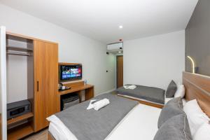 a hotel room with two beds and a flat screen tv at mayza otel in Istanbul