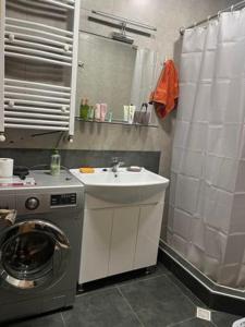 y baño con lavadora y lavamanos. en apartment N&A en Tiflis