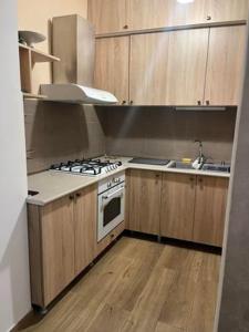 cocina con armarios de madera y horno con fogones en apartment N&A en Tiflis