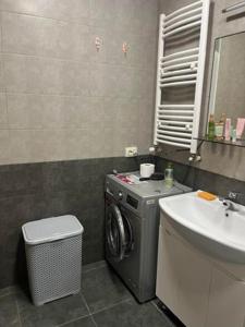 y baño con lavadora y lavamanos. en apartment N&A en Tiflis