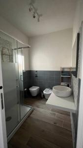 ein Badezimmer mit 2 Waschbecken, einer Dusche und 2 WCs in der Unterkunft Casa indipendente in Tonnara di Bonagia