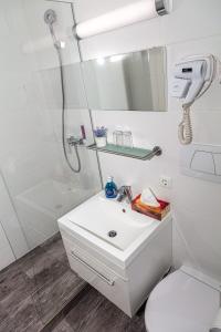 a white bathroom with a shower and a sink at Apparthotel Alte Innbrücke-24Std-Self-Check In in Neuhaus am Inn