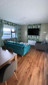 a living room with a blue couch and a table at The Chroma Cottage in Cock Hill