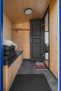 a door to a room with a bed and a window at Cool cabins Sandhornøy in Lekanger