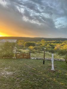 uma cerca num campo com um pôr-do-sol ao fundo em ALTOS DE PUNILLA em Casa Grande