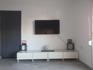 ein Wohnzimmer mit einem Tisch und einem TV an der Wand in der Unterkunft Apartamento a 100 metros de la playa in Piles