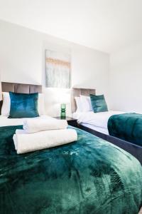 Zimmer mit 2 Betten und einem großen grünen Teppich in der Unterkunft 2 Bedroom Flat - Close to BBC studios! in Borehamwood