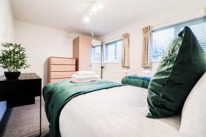 una camera da letto con un grande letto con un cuscino verde di 2 Bedroom Flat - Close to BBC studios! a Borehamwood