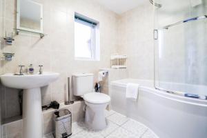 a bathroom with a toilet and a sink and a tub at 2 Bedroom Flat - Close to BBC studios! in Borehamwood