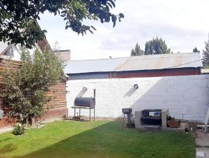 einen Grill in einem Hof neben einem Gebäude in der Unterkunft Matices Hostel Centro in El Calafate