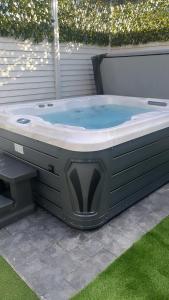 a jacuzzi tub with a bench in a yard at The Chroma Cottage in Cock Hill