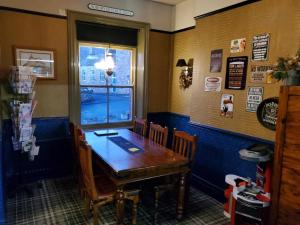 a dining room with a wooden table and a window at The Queens Arms Hotel in Acomb