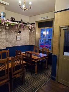 The Queens Arms Hotel في Acomb: غرفة طعام مع طاولة وكراسي خشبية