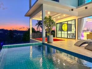 a house with a swimming pool with a sunset at Reggae Garden Villas in Salad Beach