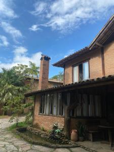 a brick house with a chimney on top of it at Pousada Chalés Vale do Sol in Conceição da Ibitipoca