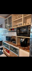 a kitchen with two microwaves on a counter at Equilibrium Pousada Familiar (orquídeas) in Torres
