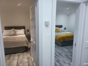 1 Schlafzimmer mit 2 Betten und einer Tür, die auf einen Flur führt in der Unterkunft Getaway Home in Manchester in Manchester