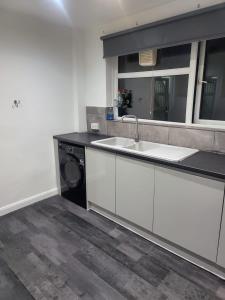 a kitchen with a sink and a washing machine at Getaway Home in Manchester in Manchester