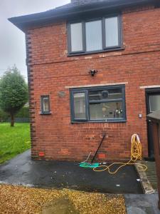 a brick house with a window with a yellow hose at Getaway Home in Manchester in Manchester