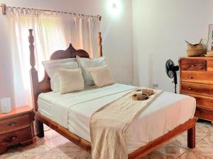 Blue Hole的住宿－The Happy Retreat Villa in Belmont, Jamaica，一间卧室配有一张大床和木制床头板