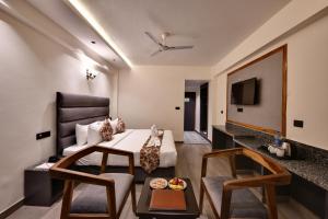 a hotel room with a bed and a table at Click Sunburry Hotel Katra in Katra