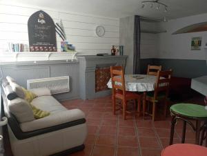 a living room with a couch and a table and a dining room at Ancien Bar Lémon Café in Sainte Anne d'Auray 