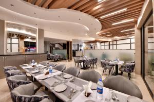 een restaurant met tafels en stoelen in een kamer bij Click Sunburry Hotel Katra in Katra