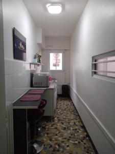 Elle comprend une petite cuisine avec un bureau et une fenêtre. dans l'établissement Nice appartement centre ville, à Nice