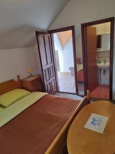 a bedroom with a bed and a table and a mirror at Prenoćište San Rooms in Livno