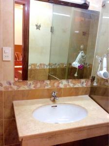 a bathroom with a sink and a mirror at Serviced Apartment next to the Hanoi Opera House Căn hộ đầy đủ tiện nghi có thang máy ngay gần Nhà Hát Lớn in Hanoi