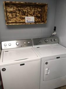 two white washing machines sitting next to each other at Caddy Corner has a hot tub just outside of town in French Lick