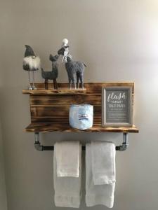 a shelf with towels and a picture of animals on it at Caddy Corner has a hot tub just outside of town in French Lick