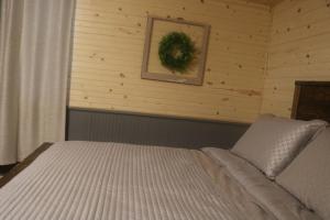 a bedroom with a bed with a wreath on the wall at Caddy Corner has a hot tub just outside of town in French Lick