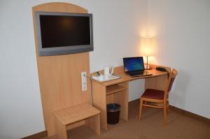 Habitación de hotel con escritorio, ordenador portátil y TV. en Brit Hotel Châteaudun, en Châteaudun