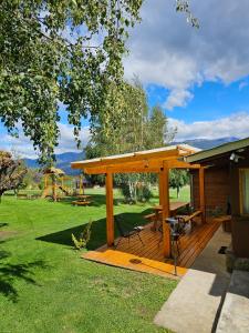 a wooden deck with a picnic table and a playground at La Yaya - Villa Turismo in El Bolsón