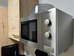 a silver microwave oven sitting on top of a counter at Barockstadt-Apartment Rastatt in Rastatt