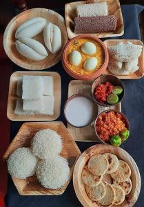 una mesa cubierta con diferentes tipos de comida en platos en Yala Leisure Villa & Safari en Tissamaharama