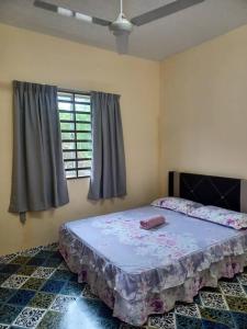 Schlafzimmer mit einem Bett und einem Fenster in der Unterkunft Homestay Fizie in Kampong Lereh