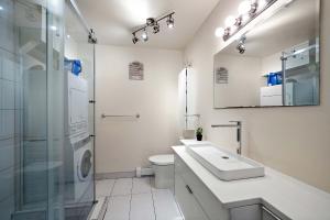 a white bathroom with a sink and a shower at DUPLEX FOR GROUP STAY_MONT-ROYAL in Montréal