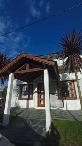 una casa con una palma di fronte di Las Grullas a Villa Gesell
