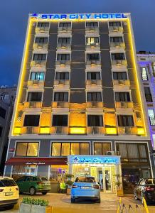 duży budynek z samochodami zaparkowanymi przed nim w obiekcie Star City Hotel w Stambule
