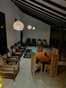 a dining room with a table and chairs and lights at Kottamba Yala Stay & Safari in Tissamaharama
