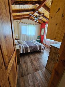 a bedroom with a bed and a ceiling fan at La Yaya - Villa Turismo in El Bolsón