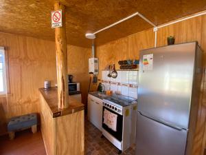 Chacao Viejo的住宿－Cabañas Los Queltehues，厨房配有不锈钢冰箱和炉灶。