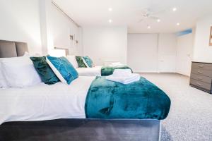 1 dormitorio grande con 1 cama grande con almohadas azules en Contractor House by BBC Studios - Free parking! en Borehamwood
