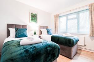 1 dormitorio con 2 camas y ventana en Contractor House by BBC Studios - Free parking! en Borehamwood