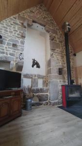Zimmer mit einem Steinkamin und einem Pferd an der Wand in der Unterkunft L'amour Breizh in Plouaret